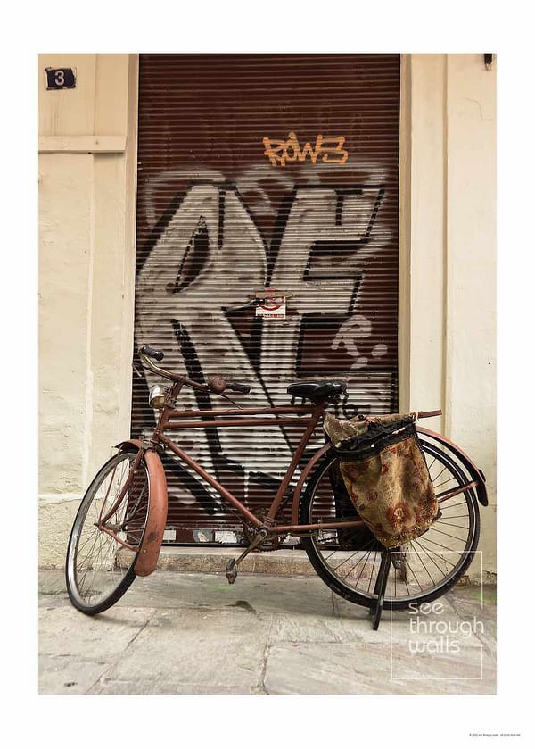 A vintage bike leans against a graffiti-covered door, capturing an urban and artistic street vibe.