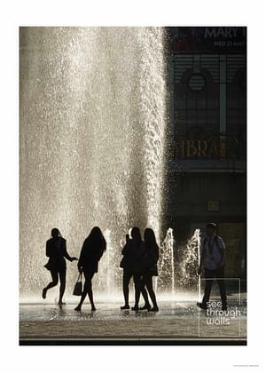 Silhouetted figures gather around a sunlit urban fountain.