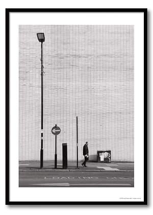 Sheffield urban photography print showing lone figure mid-stride against vast brutalist tiled wall with one-way arrow sign and lamp post