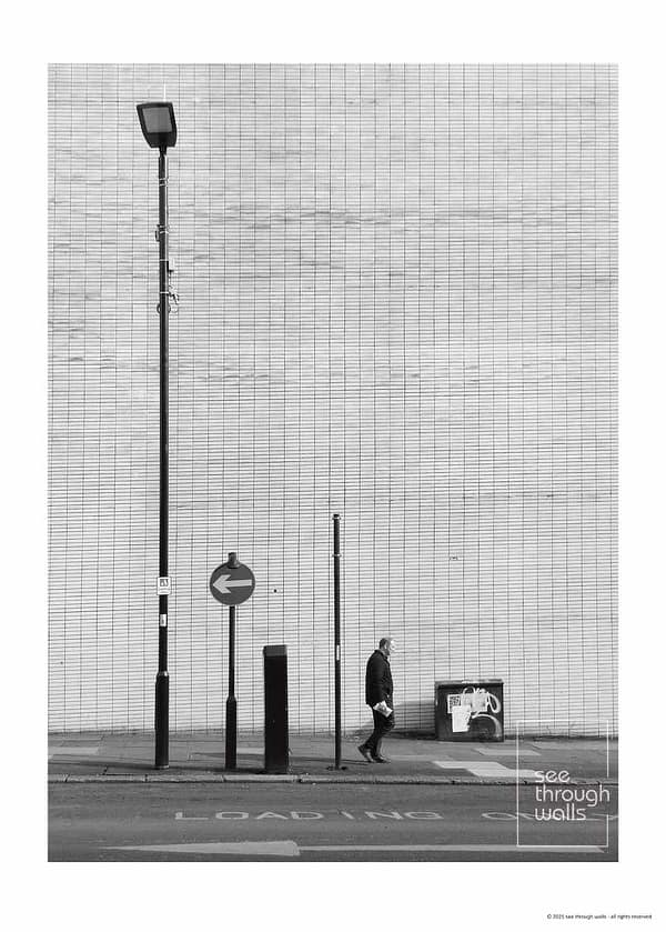Man Walking Past a Minimalist City Wall