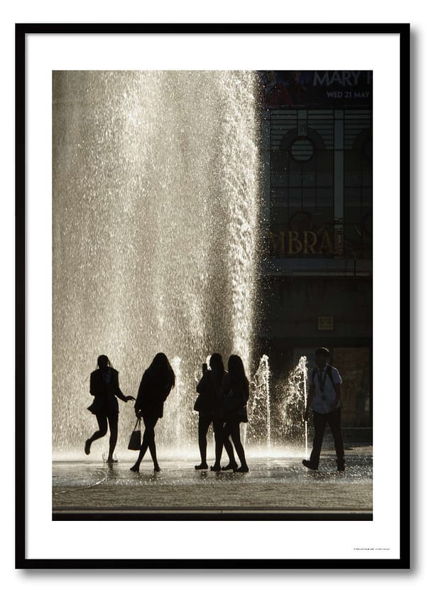 Fountain silhouettes photography print showing five school leavers backlit against cascading water with a city library in the background